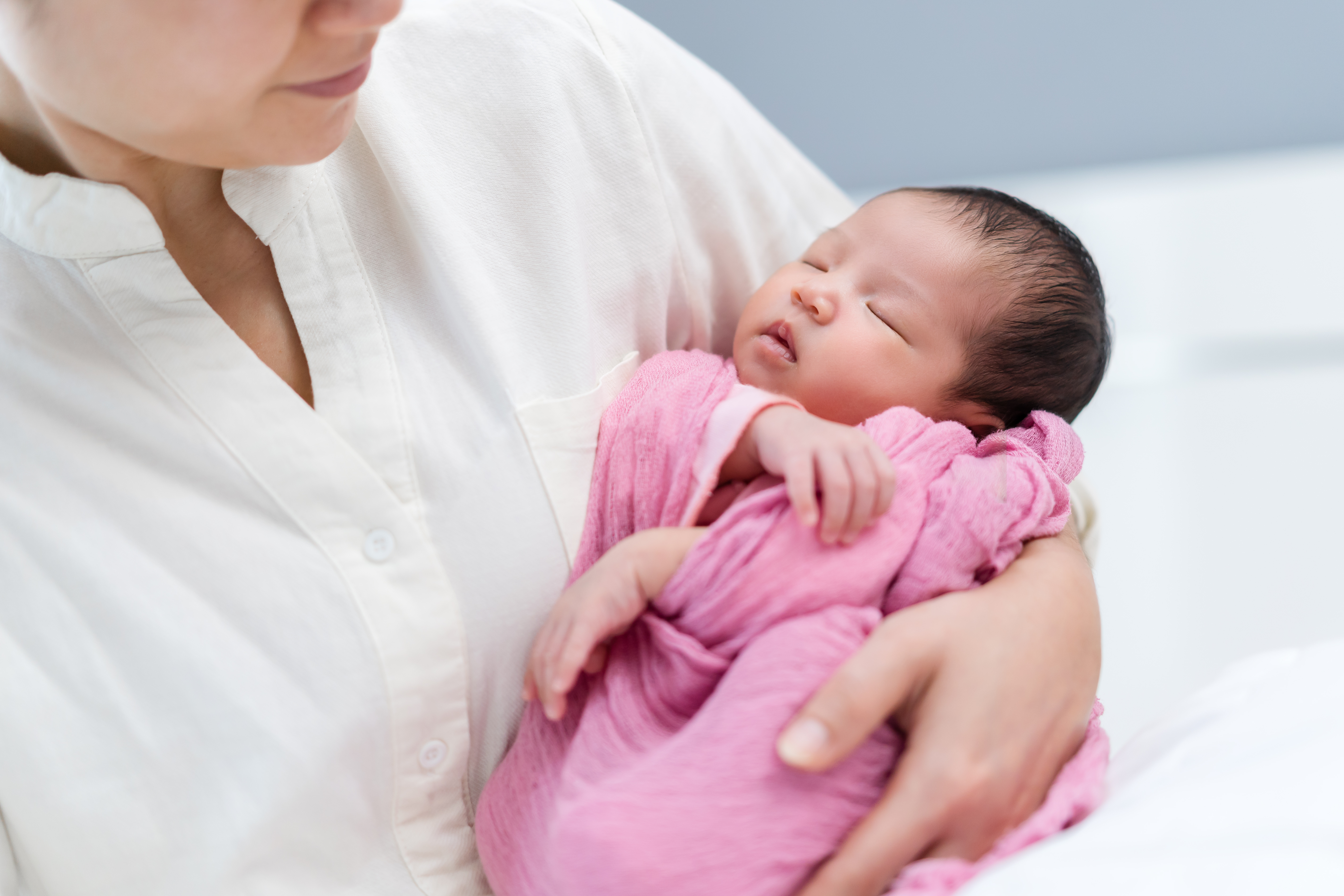 A new mother holding her sleeping newborn